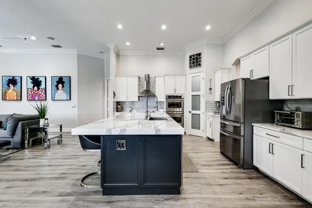 a kitchen with stainless steel appliances kitchen island granite countertop a refrigerator and a stove top oven