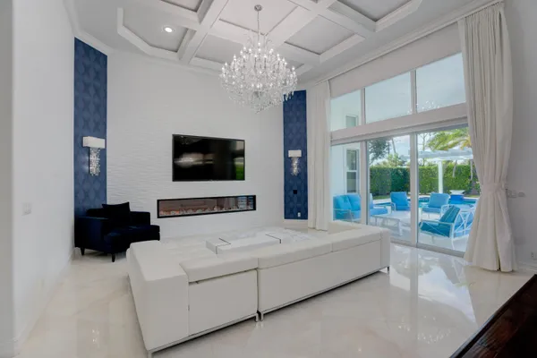 a living room with a flat screen tv and a chandelier