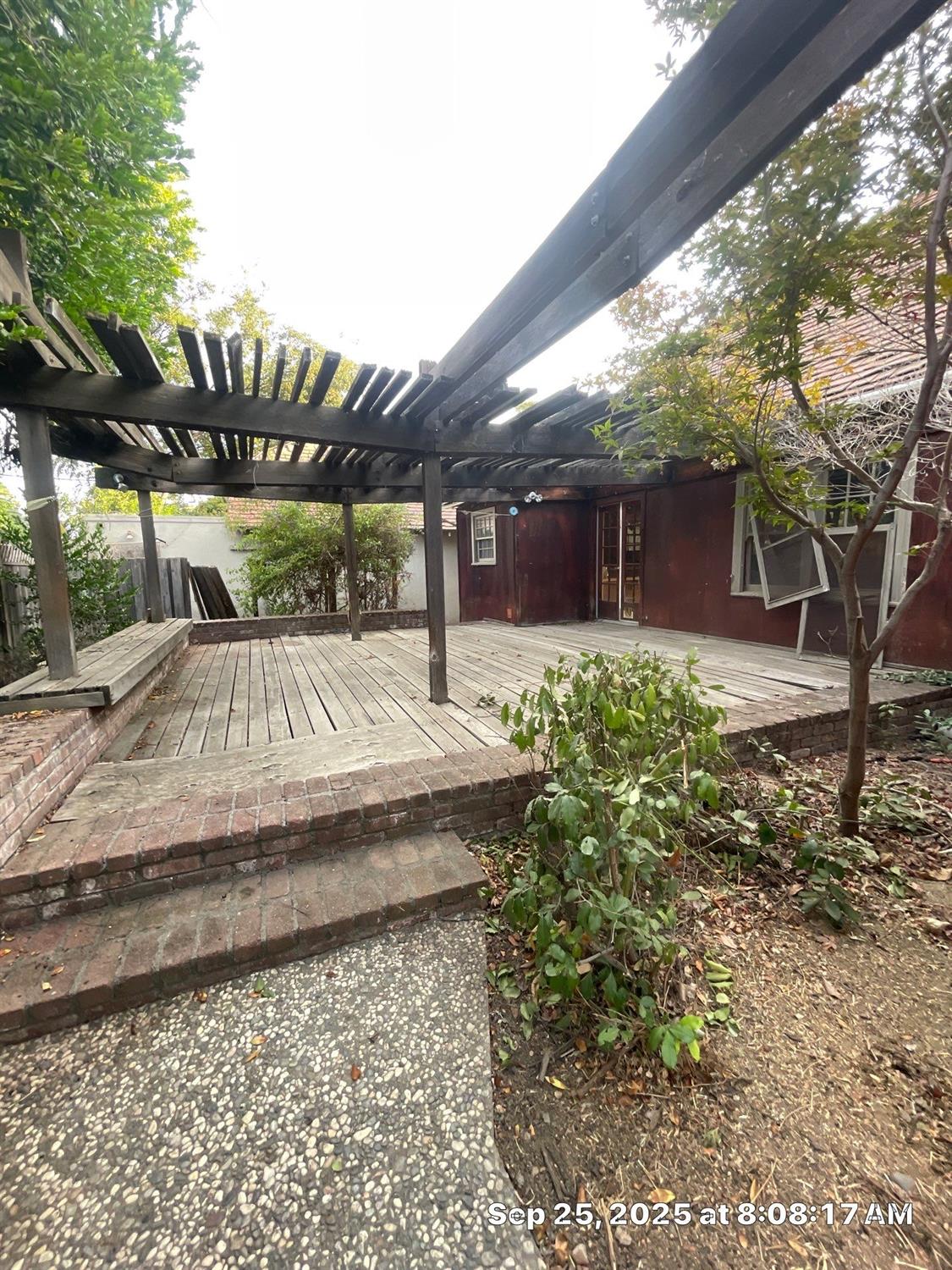 151 South Murdock Avenue Willows, CA 95988 - Photo 15 of 19 a view of a backyard with table and chairs under an umbrella with large trees