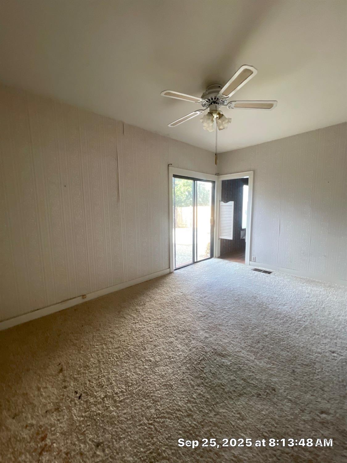 151 South Murdock Avenue Willows, CA 95988 - Photo 4 of 19 an empty room with a chandelier fan and windows