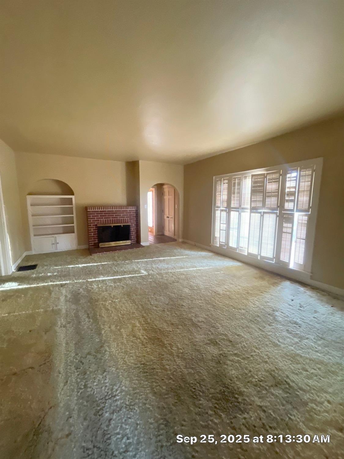 151 South Murdock Avenue Willows, CA 95988 - Photo 7 of 19 a view of an empty room with a fireplace and a window