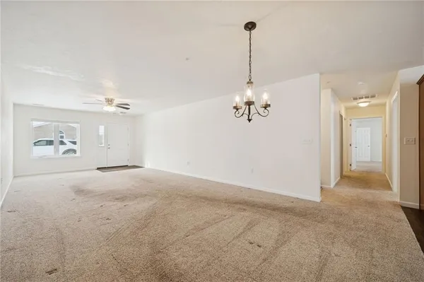 a view of a room with a chandelier fan and windows