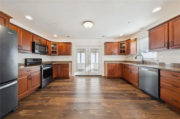 a kitchen with granite countertop a refrigerator and a stove top oven