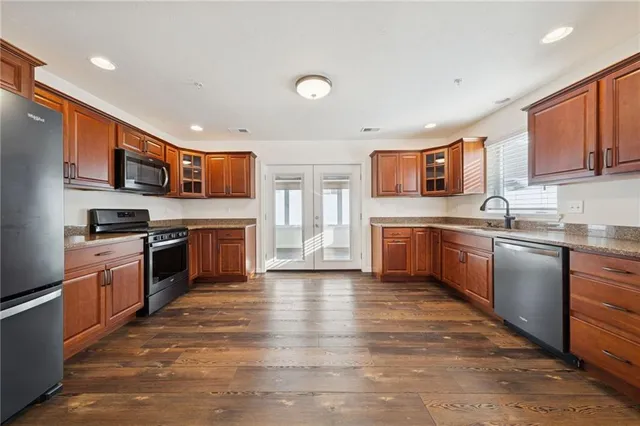 a kitchen with granite countertop a refrigerator and a stove top oven
