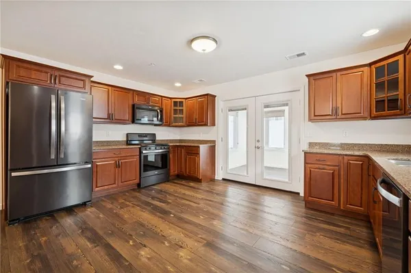 a large kitchen with stainless steel appliances a large counter top a sink and a stove