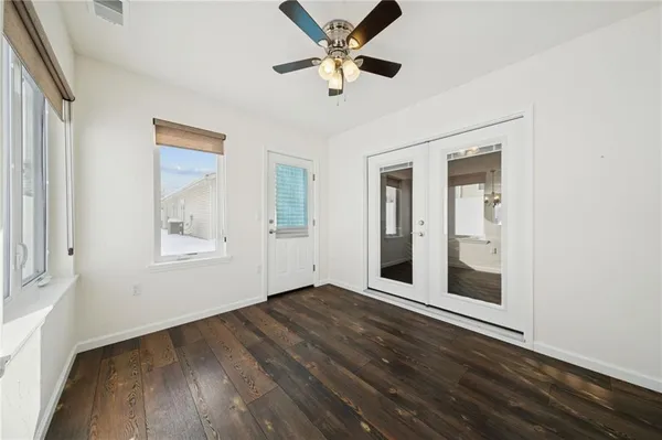 a view of a hallway with wooden floor and a bathroom