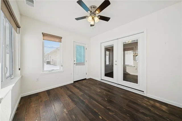 a view of a hallway with wooden floor and a bathroom