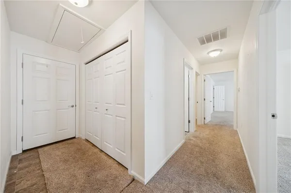 an empty room with chandelier fan and windows