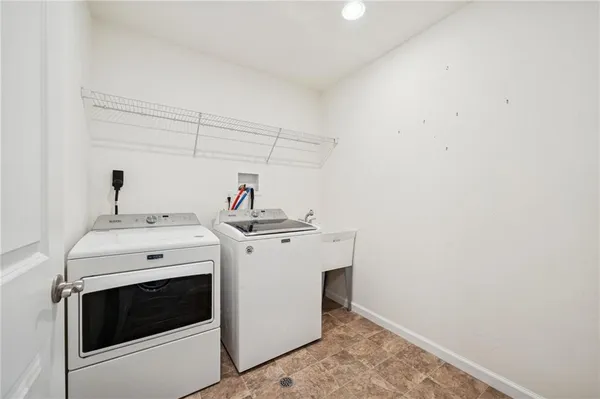 an empty room with chandelier fan and windows