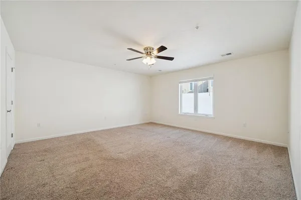 an empty room with closet and a ceiling fan