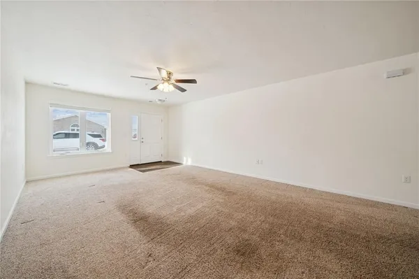 a view of a livingroom with a ceiling fan and wooden floor