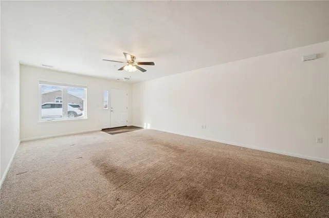 a view of a livingroom with a ceiling fan and wooden floor