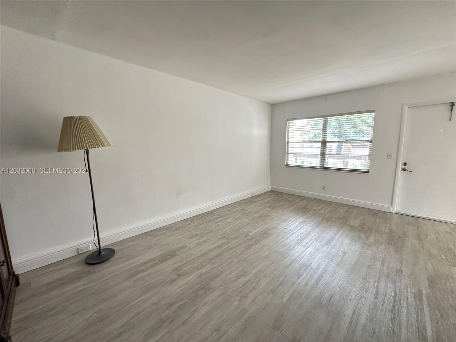 445 Mansfield K, Unit 445 Boca Raton, FL 33434 - Photo 6 of 12 a view of empty room with wooden floor and window