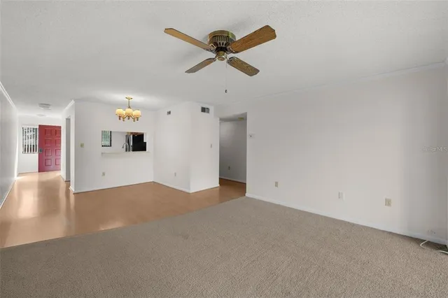 a view of empty room with wooden floor and ceiling fan