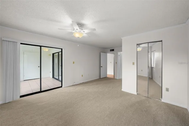 an empty room with fan and entrance