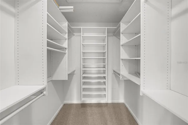 a view of walk in closet with empty racks