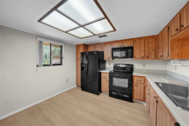 a kitchen with stainless steel appliances granite countertop a stove a sink dishwasher a refrigerator and a microwave oven