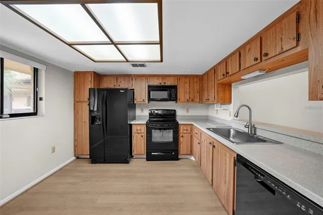 a kitchen with stainless steel appliances granite countertop a refrigerator a sink a stove and dishwasher