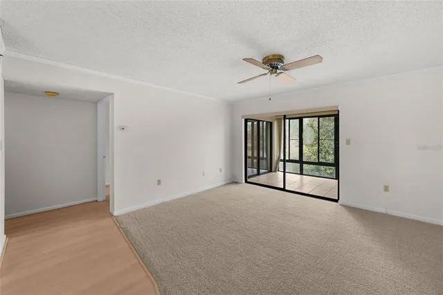 a view of a livingroom with a ceiling fan and window