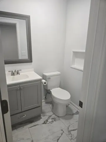 a bathroom with a toilet sink and mirror