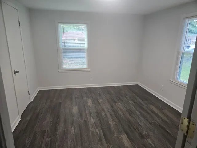 a view of a room with wooden floor and window