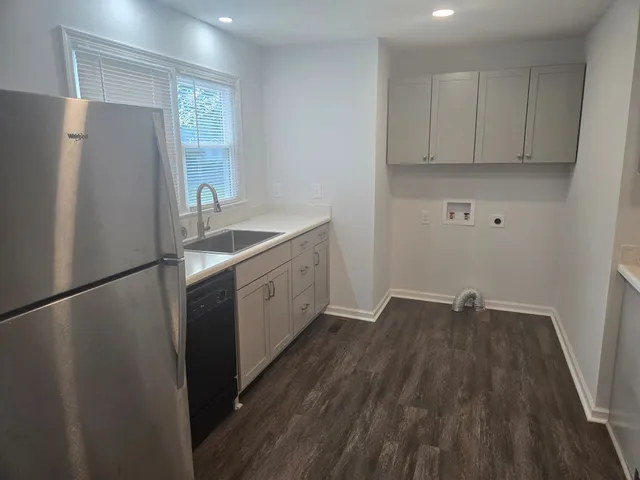 a kitchen with a refrigerator sink and cabinets