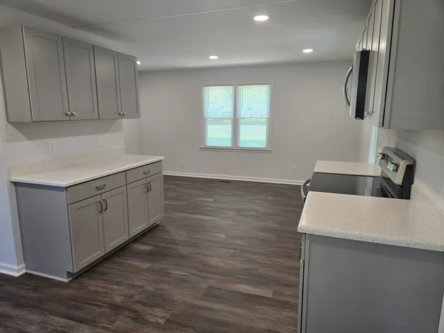 a kitchen with a sink cabinets and wooden floor