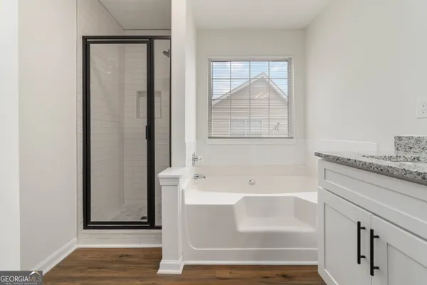 a bathroom with a tub shower and sink
