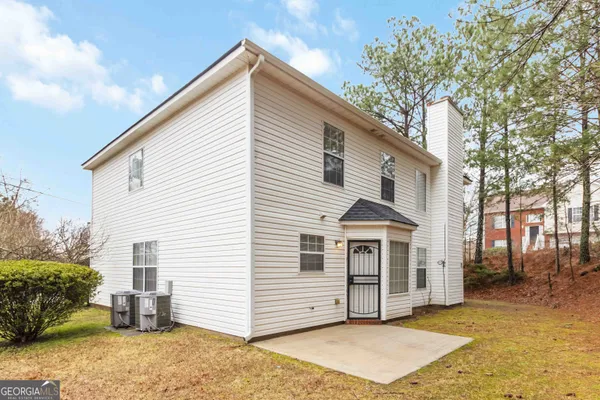 a view of a white house with a large window and large trees
