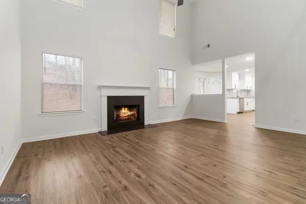 a view of empty room with wooden floor and fireplace
