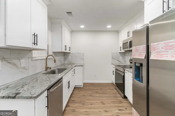 a kitchen with stainless steel appliances granite countertop a sink and a stove