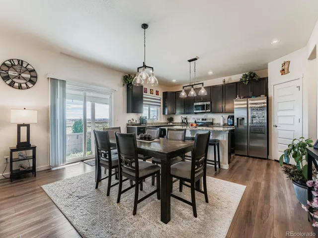 a view of a dining room and livingroom with furniture wooden floor a chandelier