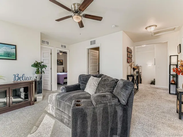 a bedroom with a bed a dresser and a chandelier