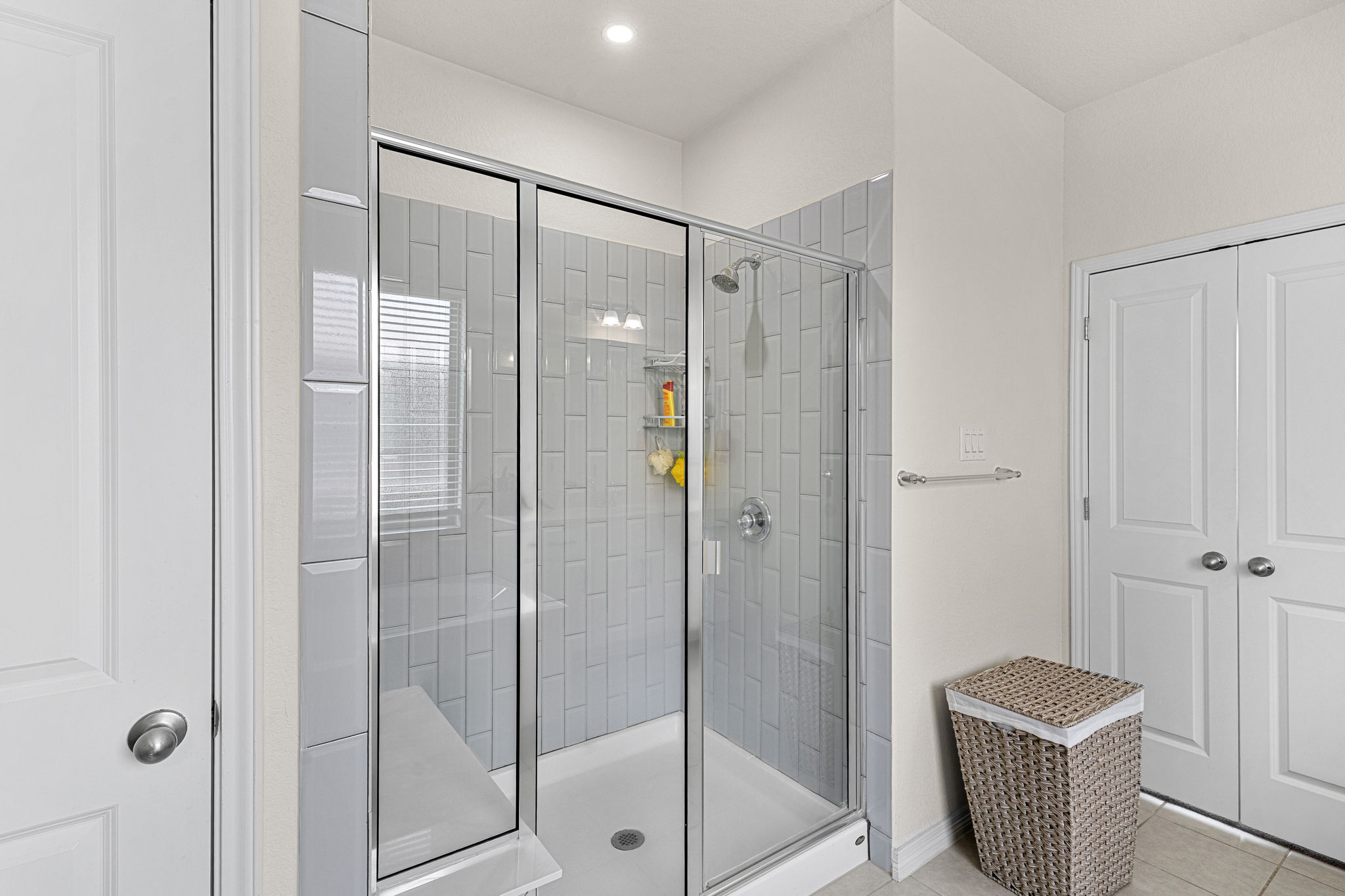 20813 Carries Ranch Road Pflugerville, TX 78660 - Photo 20 of 40 Crisp white trim borders a modern glass-enclosed shower detailed with classic vertical subway tiling.