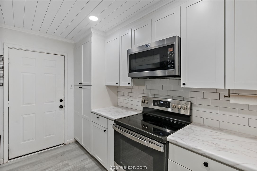8801 Old Reliance Road Bryan, TX 77808 - Photo 12 of 24 Subway tile backsplash and white cabinetry create a bright, timeless kitchen.