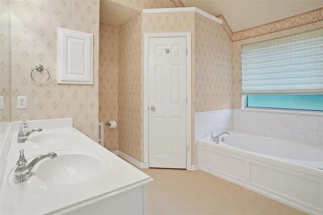 a bathroom with a tub sink and mirror
