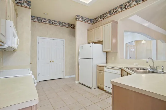 a kitchen with a refrigerator a sink and cabinets