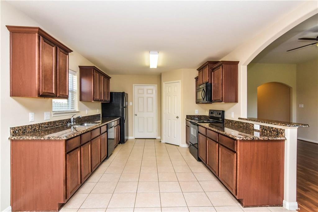 216 Mill Street Anna, TX 75409 - Photo 5 of 22 a kitchen with stainless steel appliances granite countertop a stove top oven a sink dishwasher and a refrigerator