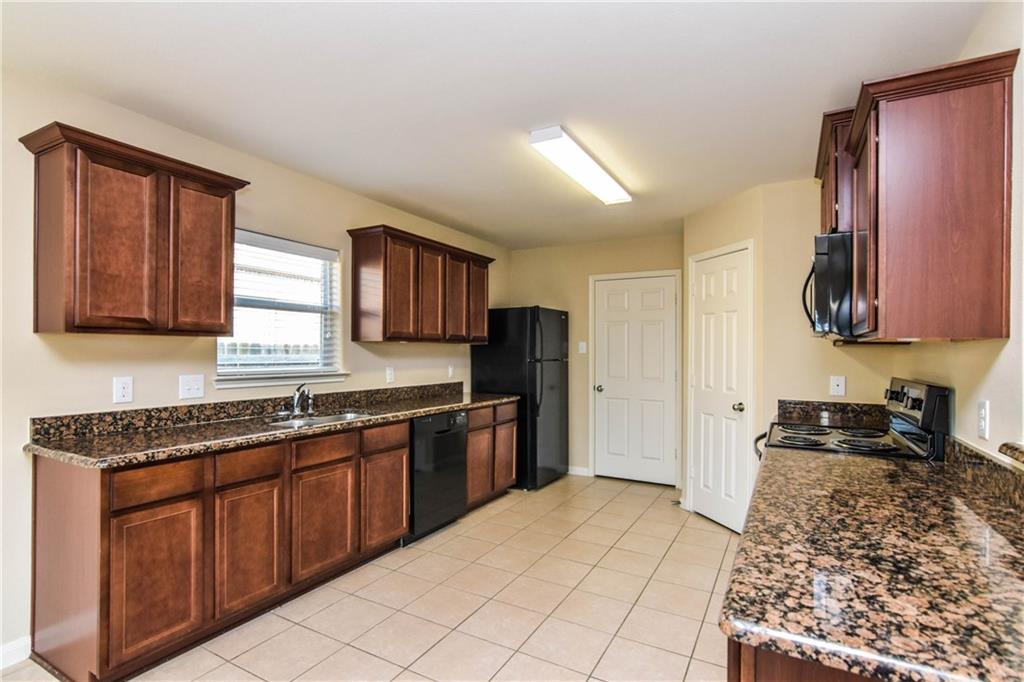 216 Mill Street Anna, TX 75409 - Photo 6 of 22 a kitchen with stainless steel appliances granite countertop a stove sink and cabinets