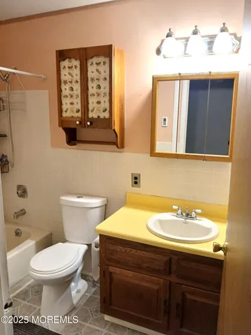 a bathroom with a toilet a sink and mirror