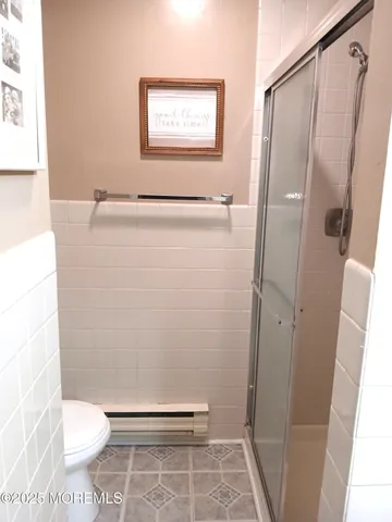 a bathroom with a toilet and a shower