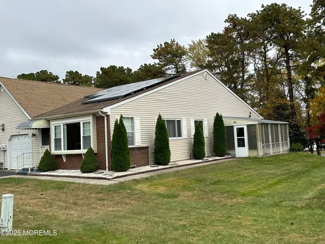 a view of a house with a yard and potted plants