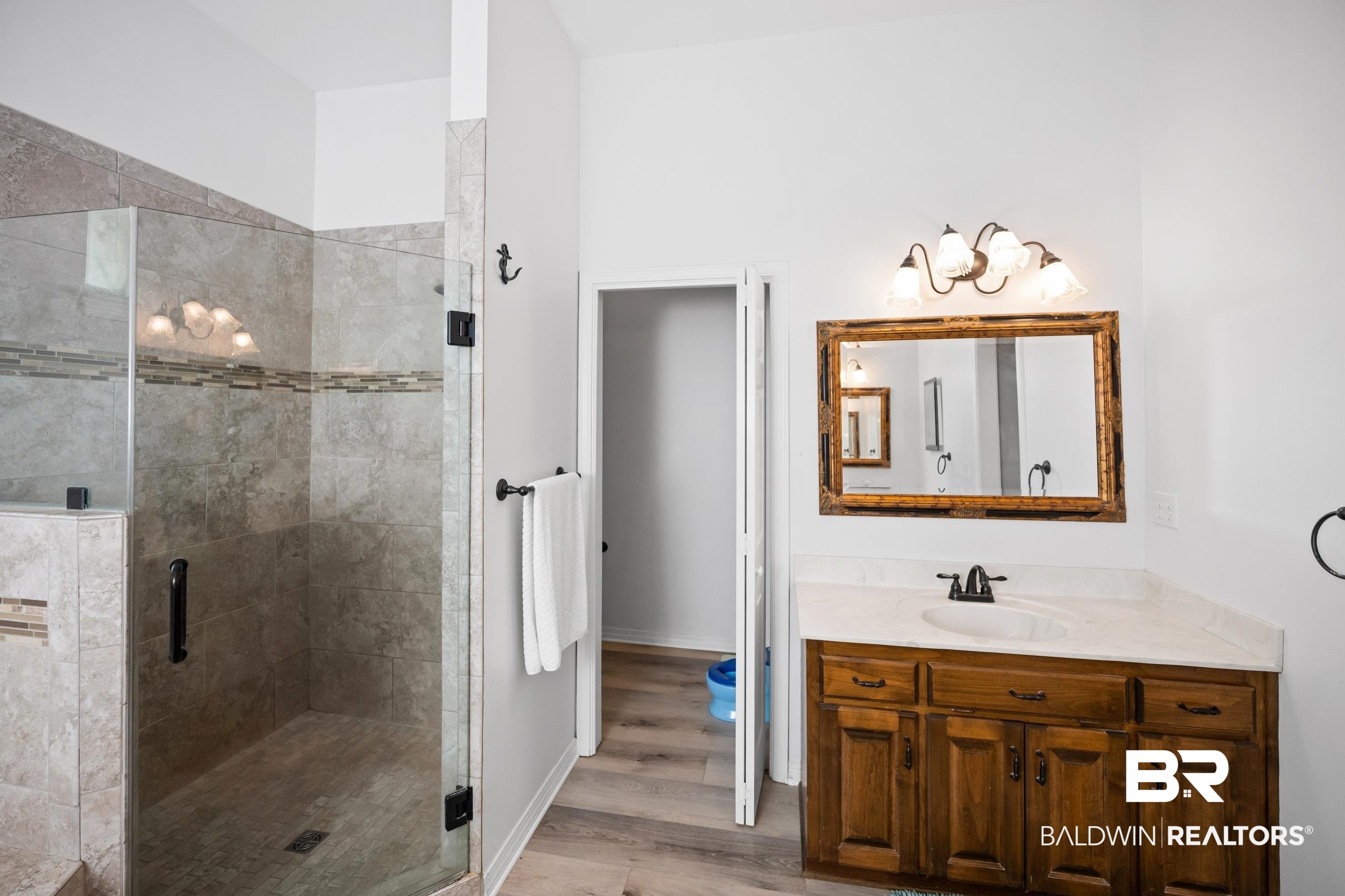 8585 Bay Harbor Road Elberta, AL 36530 - Photo 25 of 51 Bathroom with vanity, a shower stall, and wood finished floors
