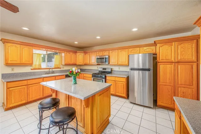 a kitchen with stainless steel appliances granite countertop a refrigerator a sink dishwasher a stove with white cabinets and wooden floor