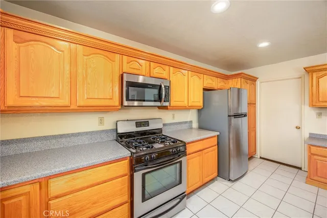 a kitchen with stainless steel appliances granite countertop a refrigerator stove top oven and sink