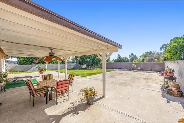 a view of a patio with a table and chairs under an umbrella