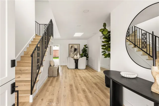 a view of a hallway with wooden floor and entryway