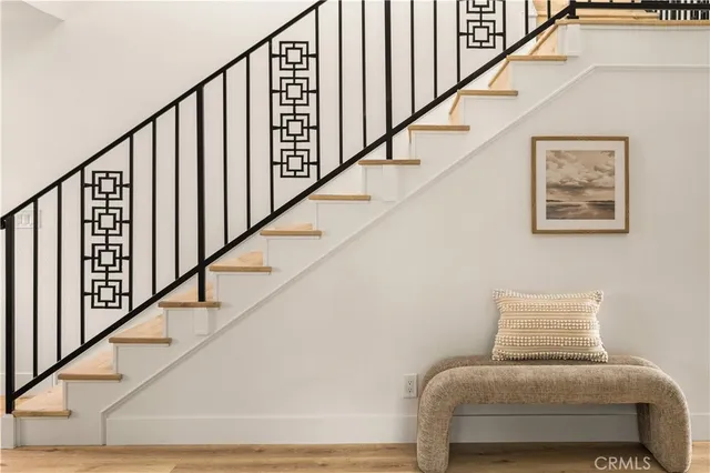 a view of a hallway with wooden floor and staircase