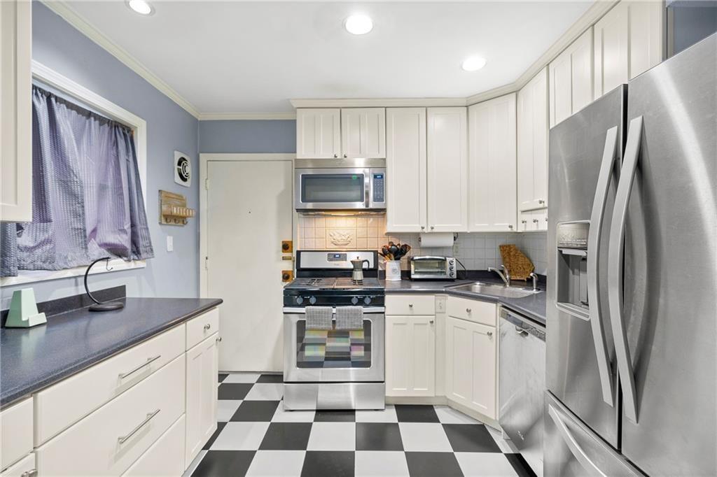 3660 Peachtree Road Northeast, Unit 6A Atlanta, GA 30319 - Photo 6 of 13 a kitchen with a refrigerator a sink and cabinets