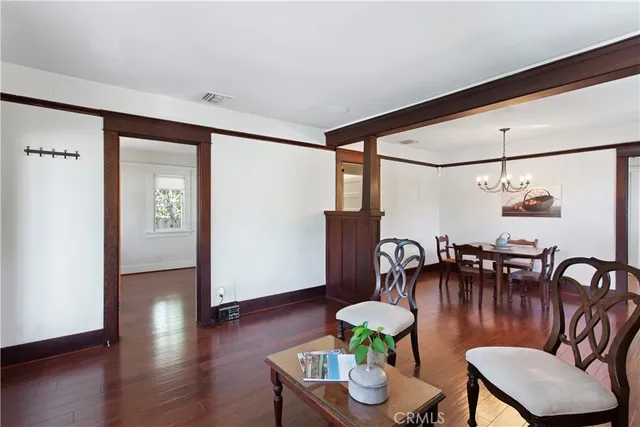 a dining room with furniture a chandelier and wooden floor